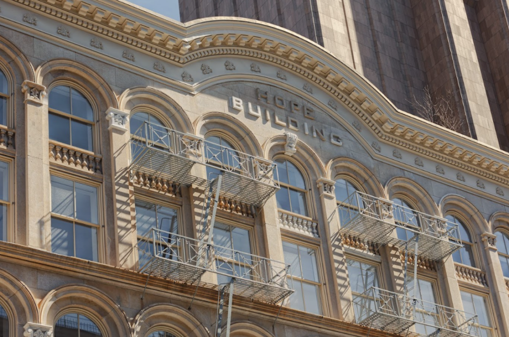 Close-up of the "Hope Building" facade with arched windows and fire escapes, showcasing architectural detail.
