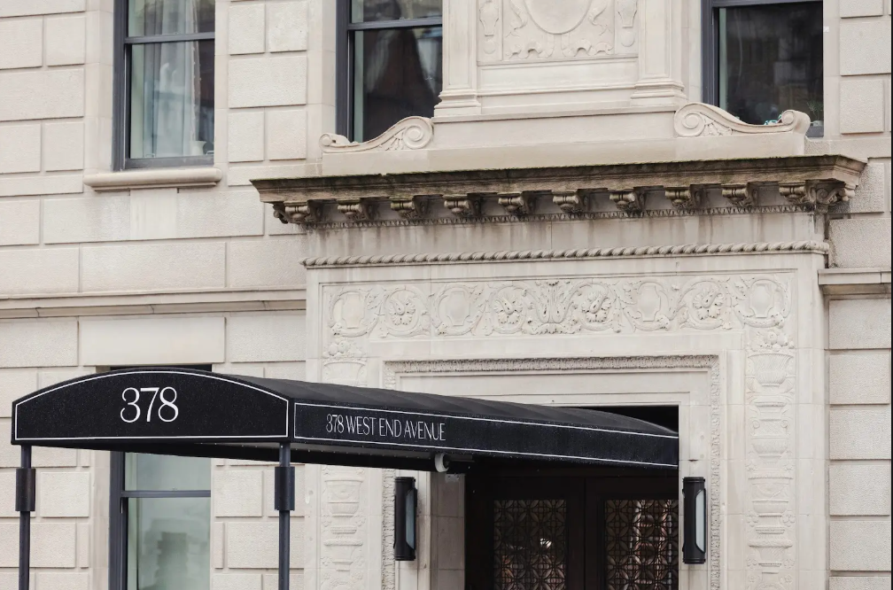 Close-up of a building entrance with a black awning displaying "378 West End Avenue" and ornate architectural details.